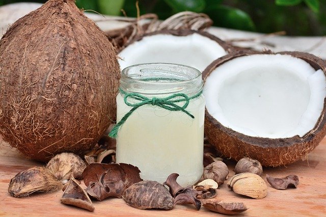 kokosová olej ve sklenici a kokosový ořech